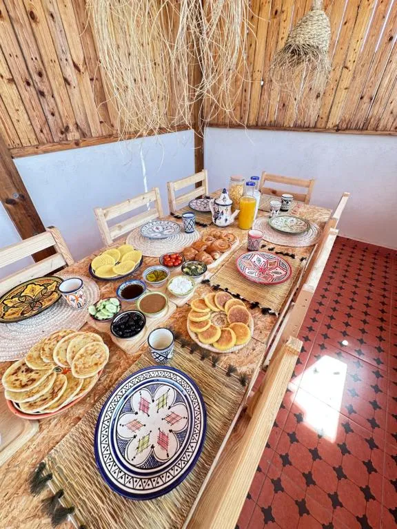 Breakfast table with Moroccan pancakes, bread, tea and orange juice