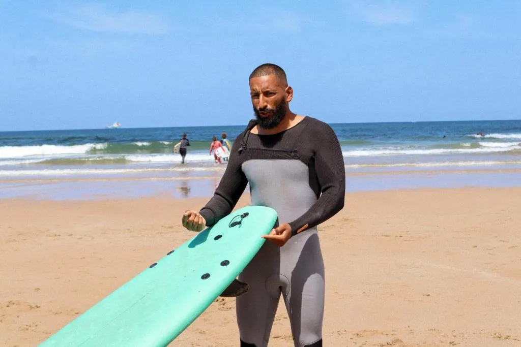 Jamal explaining a wave to surf students on the beach in Taghazout Bay