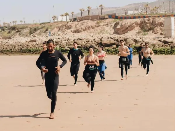 Coach Jamal leading surf warmup with students on Moroccan beach
