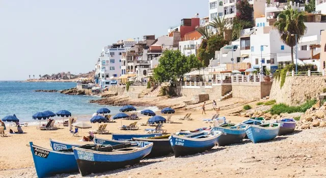 Sunset over Taghazout surf village with oceanfront cafés and surfers